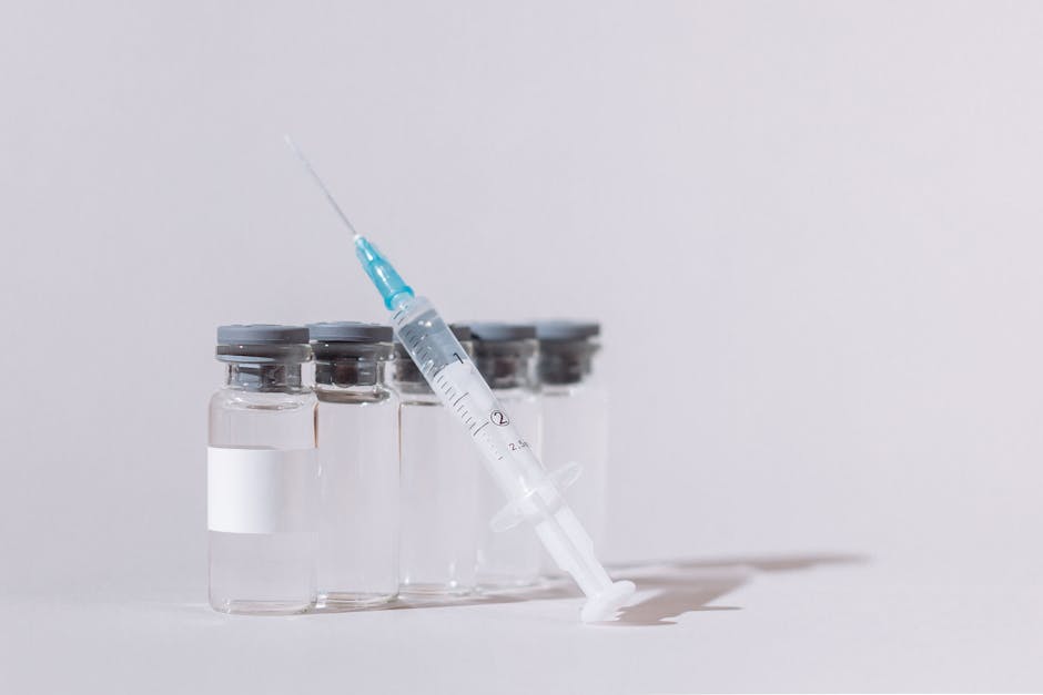 Close-up of vaccine vials with a syringe, emphasizing healthcare and vaccination.